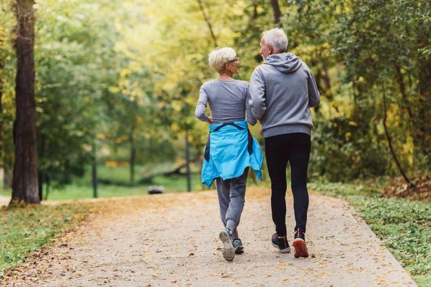 seniors couple taking a walking practicing wellness for seniors