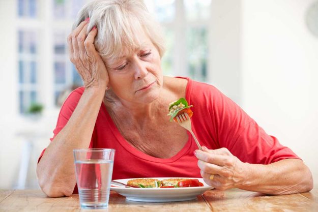 Sick older woman trying to eat Sick older woman trying to eat