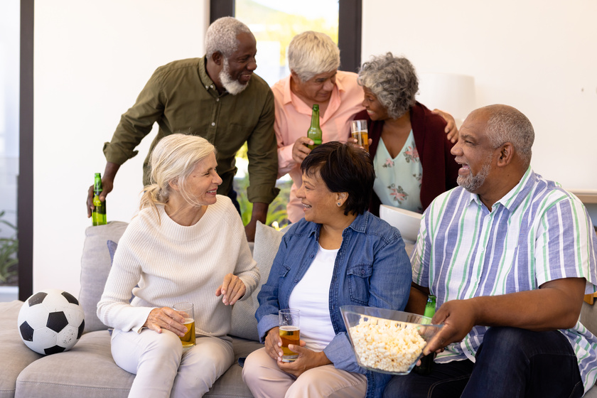 Cheerful multiracial senior friends talking while enjoying beer Cheerful multiracial senior friends talking while enjoying beer