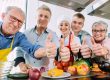 Trainees and their nutritionist in a training kitchen showing thumbs