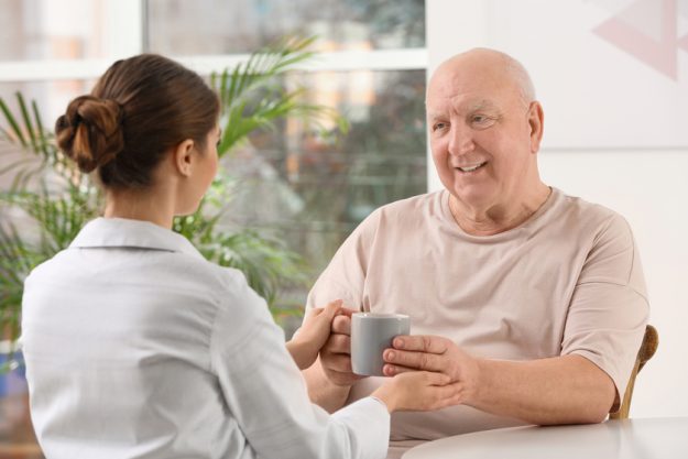 Nurse giving cup of tea to elderly man indoors. Assisting senior How Moving To A Retirement Community In Boca Raton, FL Brings Peace Of Mind To Your Family