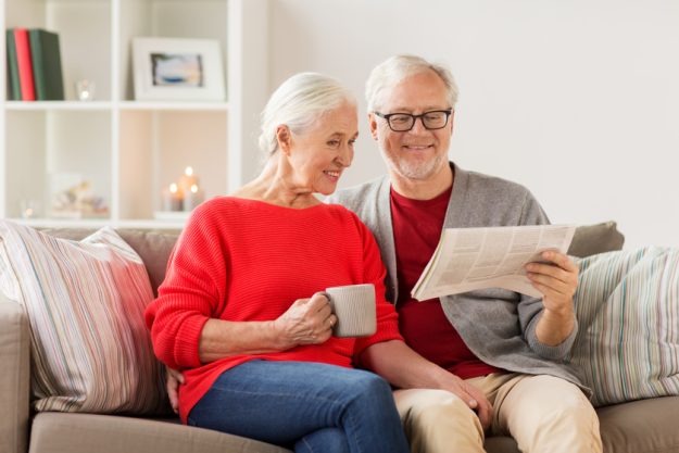 happy senior couple reading newspaper at christmas 4 Ways Retirement Homes In Florida Keeps Residents Safe During Winter