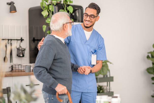 Nurse assisting a patient to walk with a walking stick 5 Reasons Why Veterans Love Retiring At Boca Raton, FL Senior Living