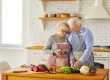 Mature married couple in aprons together prepare dinner