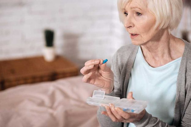 Side view of senior woman taking pill Side view of senior woman taking pill