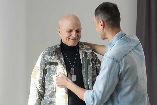 Veteran soldier in military uniform with son Veteran soldier in military uniform with son
