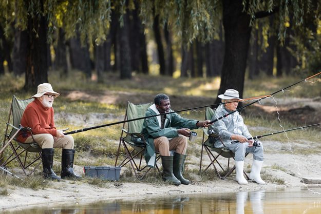 Multiethnic elderly men with fishing rods Multiethnic elderly men with fishing rods