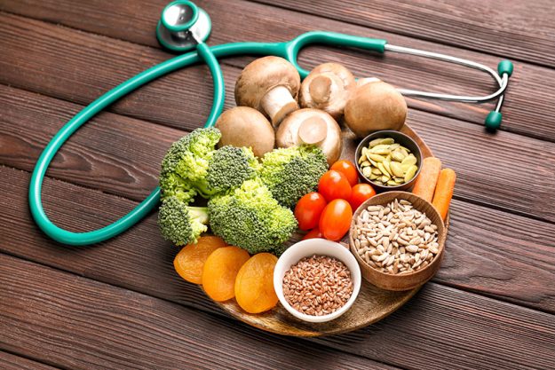 Plate with healthy products and stethoscope on wooden table Plate with healthy products and stethoscope on wooden table