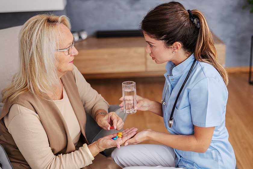Blond senior woman sitting at home and holding hand Blond senior woman sitting at home and holding hand