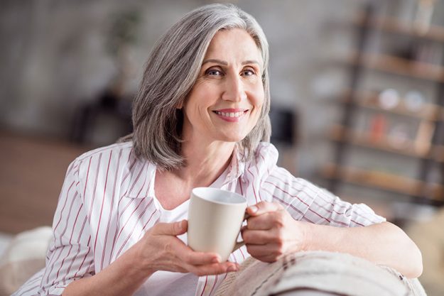 Photo of happy cheerful positive old lady good mood hold hand mug Photo of happy cheerful positive old lady good mood hold hand mug