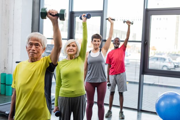 group interracial senior people exercising dumbbells sports center group interracial senior people exercising dumbbells sports center