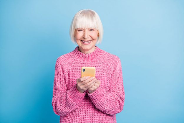 Photo portrait of smiling old woman holding phone