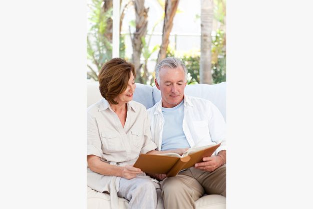 Seniors looking at their photo album at home Seniors looking at their photo album at home