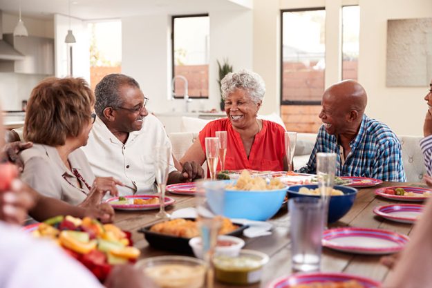 Grandfather making a toast at the dinner table celebrating with his family Grandfather making a toast at the dinner table celebrating with his family