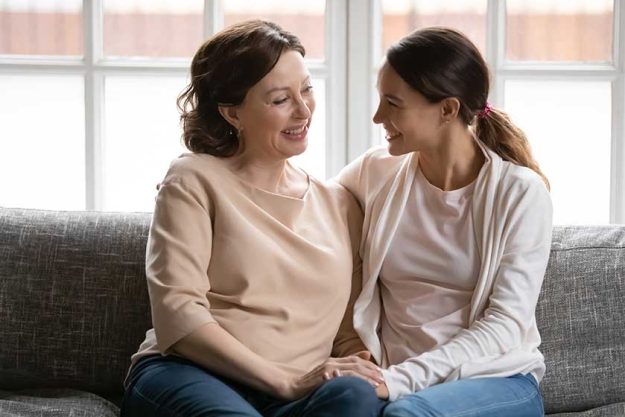 happy middle aged mother and grownup daughter holding hands happy middle aged mother and grownup daughter holding hands