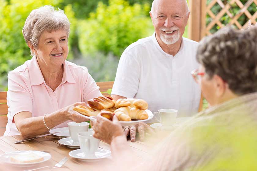 woman her old age handing pastry her colleague friend afternoon woman her old age handing pastry her colleague friend afternoon