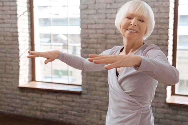 Elderly woman dancing in ballroom