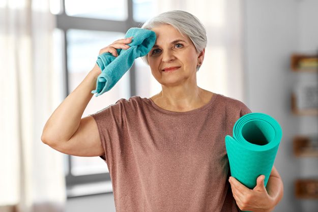 Happy tired senior woman with yoga mat and towel Happy tired senior woman with yoga mat and towel