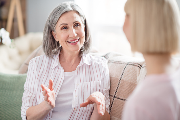 portrait of charming cheerful persons sit on sofa look each other portrait of charming cheerful persons sit on sofa look each other