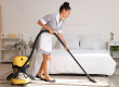 pretty chambermaid cleaning hotel room