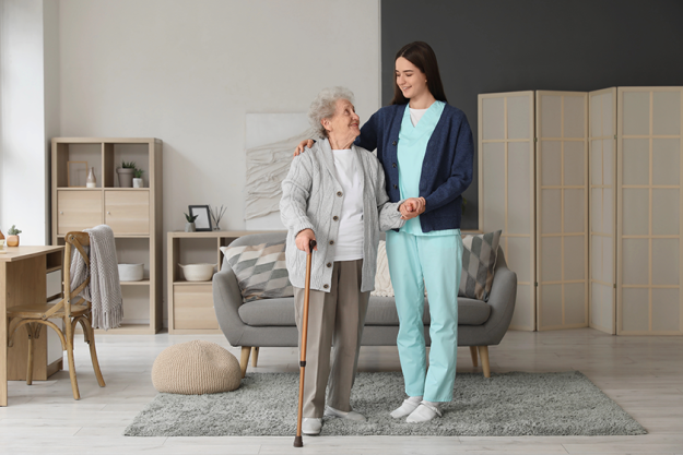 young caregiver helping senior woman young caregiver helping senior woman